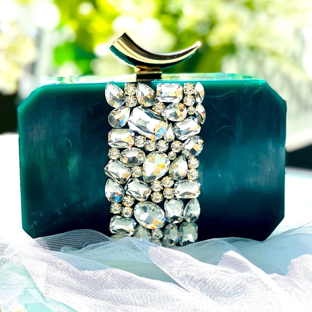 Green resin clutch with stone embellishments at the center